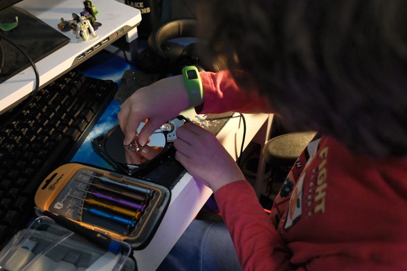 A young child exploring the internal components of a hard drive.